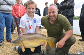 Getting out there on the bank and mixing with the public is part of the Korda policy. Here's Adam Penning with a happy young carper.