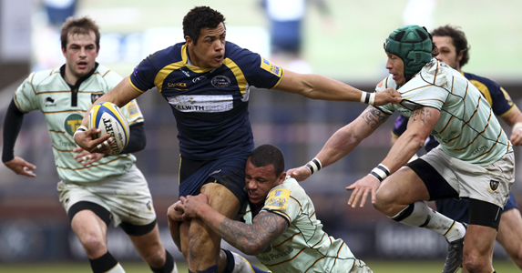 Luther Burrell (c) is tackled by Courtney Lawes of Northampton Saints