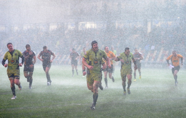 Take cover! Players and officials at the Dragons v Saints match head for the changing rooms as the storm hits