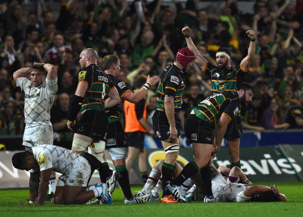 Joy and pain: Northampton's players celebrate their win while the Tigers are floored